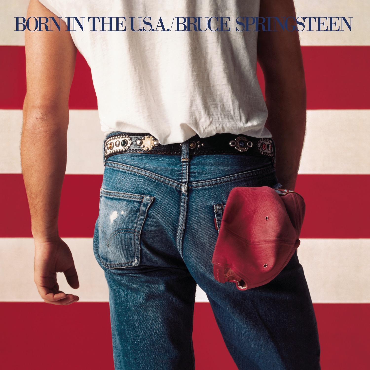 Bruce Springsteen photographié de dos, en t-shirt blanc et jean, une casquette de baseball rouge glissée dans la poche arrière, devant un fond de bandes rouges et blanches du drapeau américain, pour la pochette de l'album Born in the U.S.A.